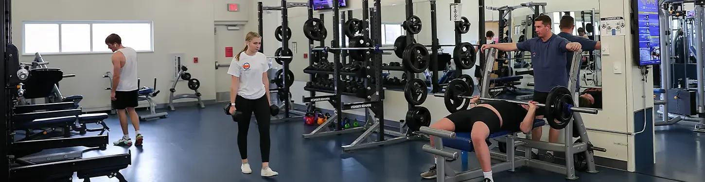 students using weights in the wellness center